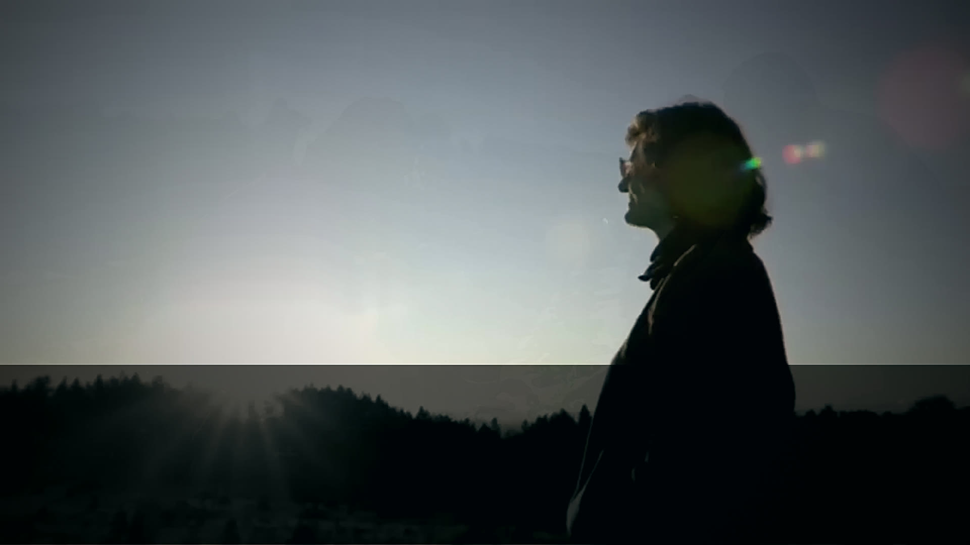 Dr. Elaine Ingham in silhouette on a hilltop at sunrise.